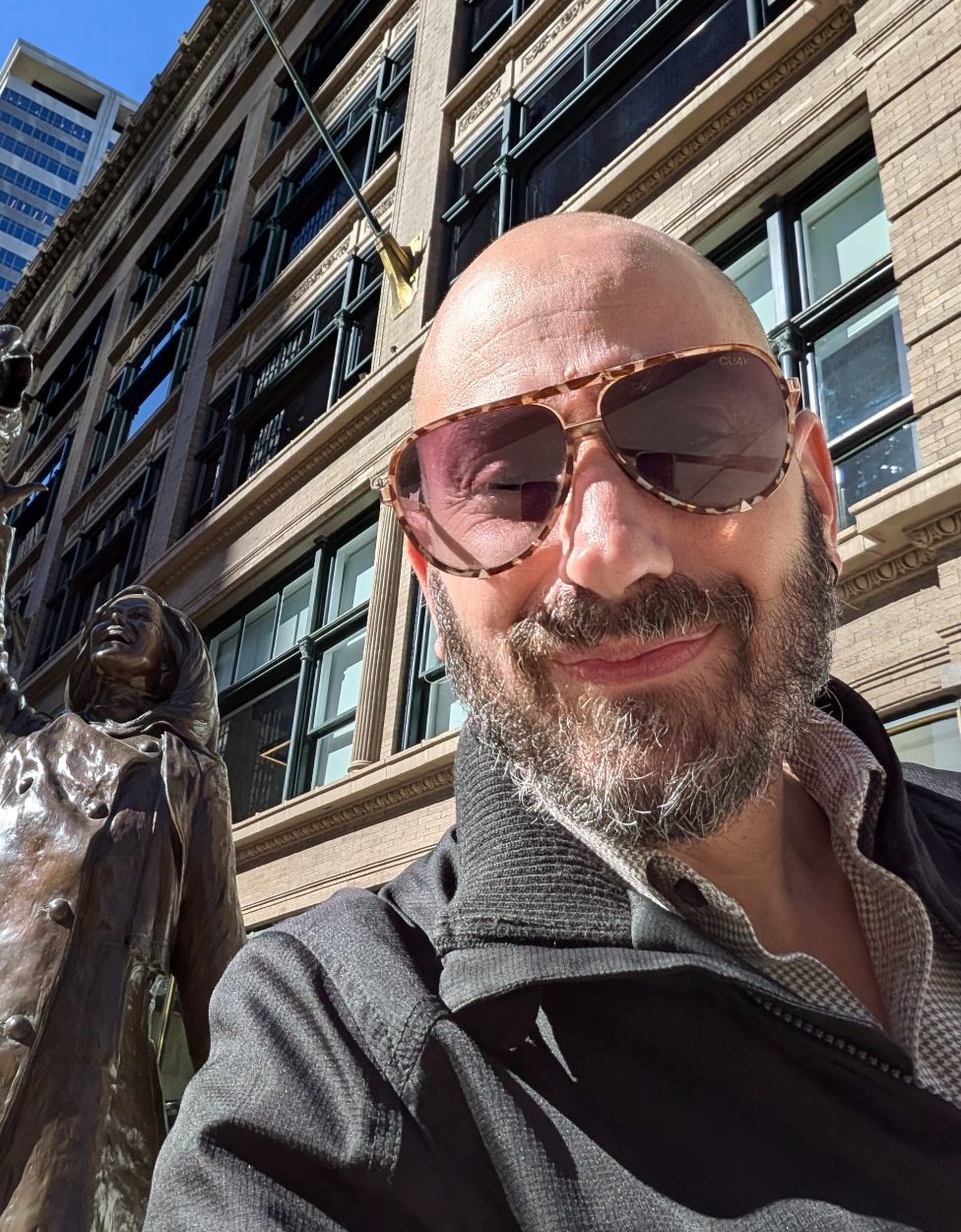 Michael Silvers in Minneapolis, beside the Mary Tyler Moore statue, mid hat-toss