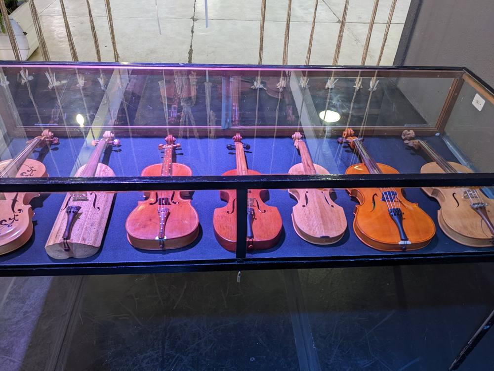 Seven rabecas lying in a glass case at the exhibition