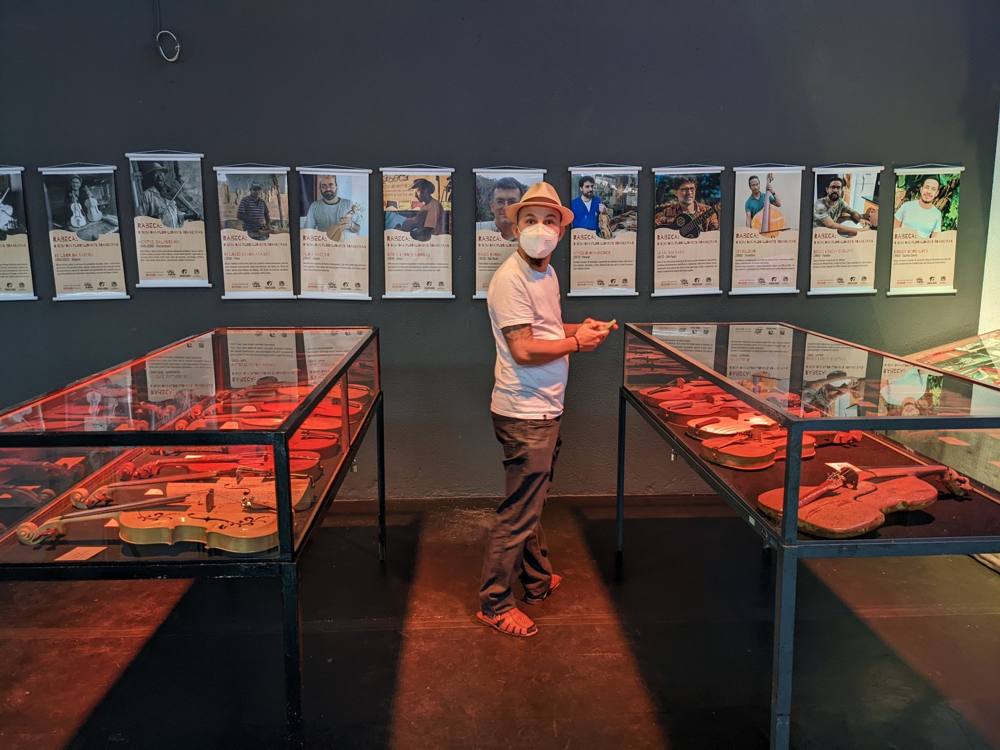 Inside the Exposição de Rabecas: glass cases of rabecas under the portrait banners