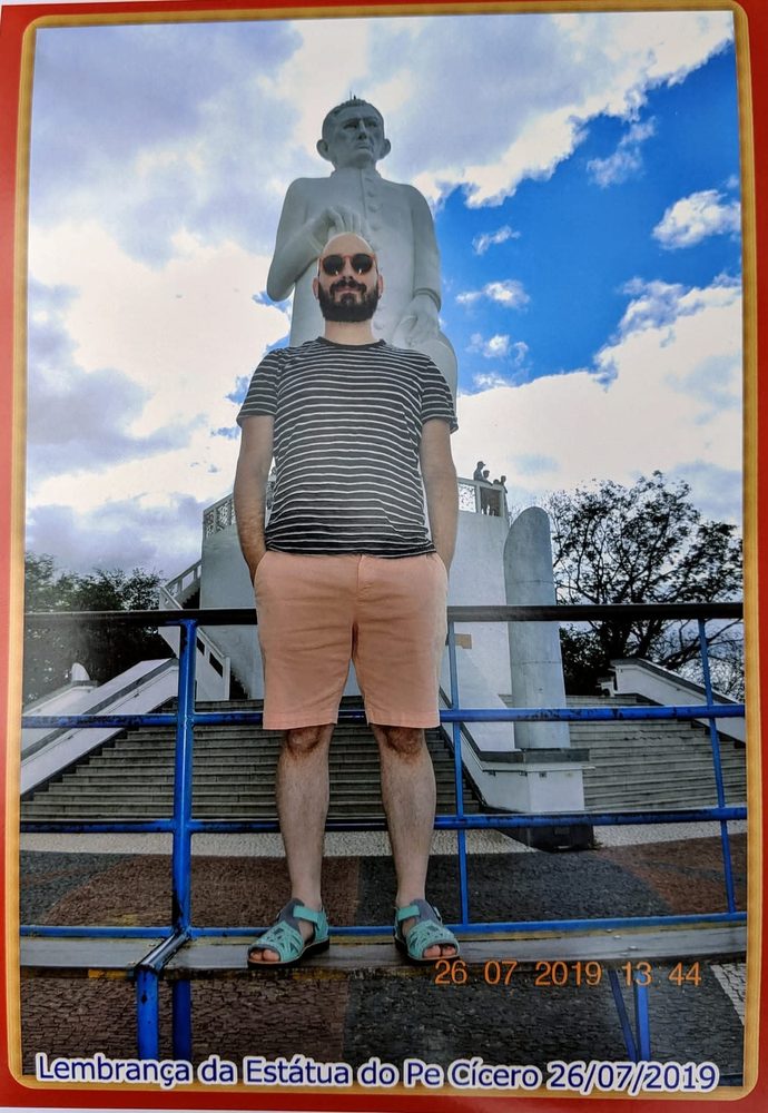 Michael Silvers standing before the colossal statue of Padre Cícero in Juazeiro do Norte, in a souvenir print dated 26/07/2019