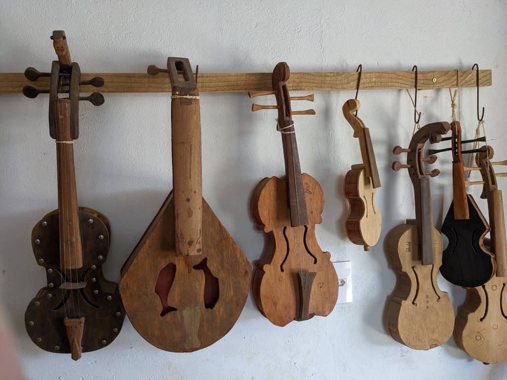 Close-up of rabecas on a rail, one with fish-shaped soundholes