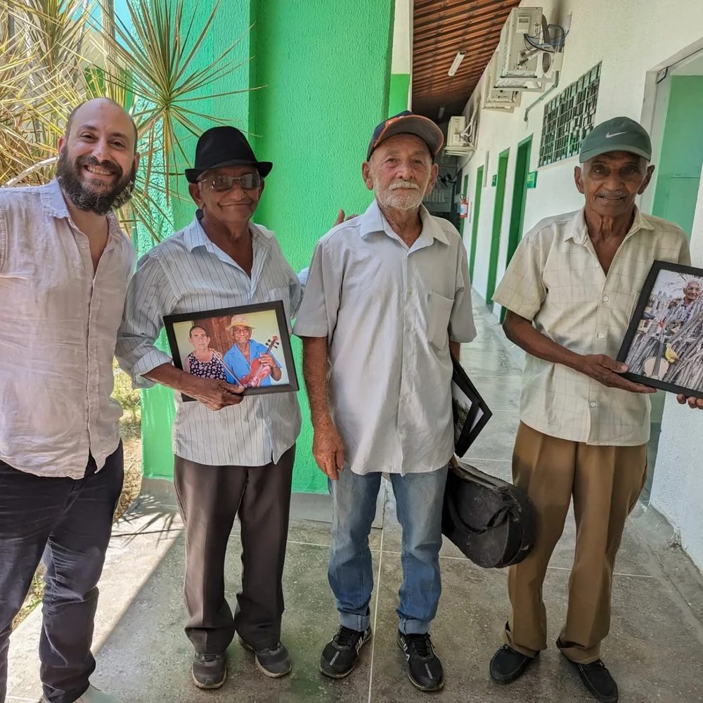 Michael Silvers with three rabequeiros at the Federal Institute in Tauá, two of them holding framed portraits