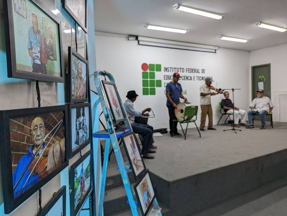 Framed portraits on the wall of the Federal Institute auditorium in Tauá while musicians perform on stage